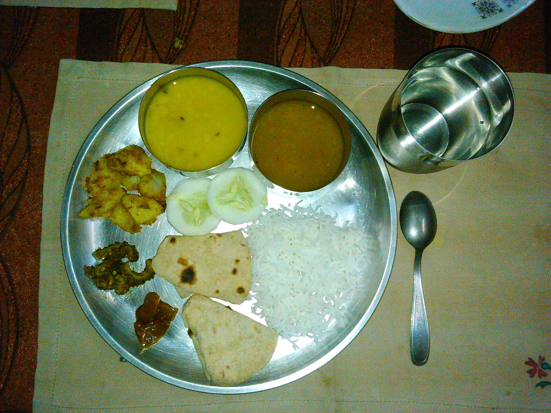 A homestyle steel thali of dal, rice, roti, sabzi and salad