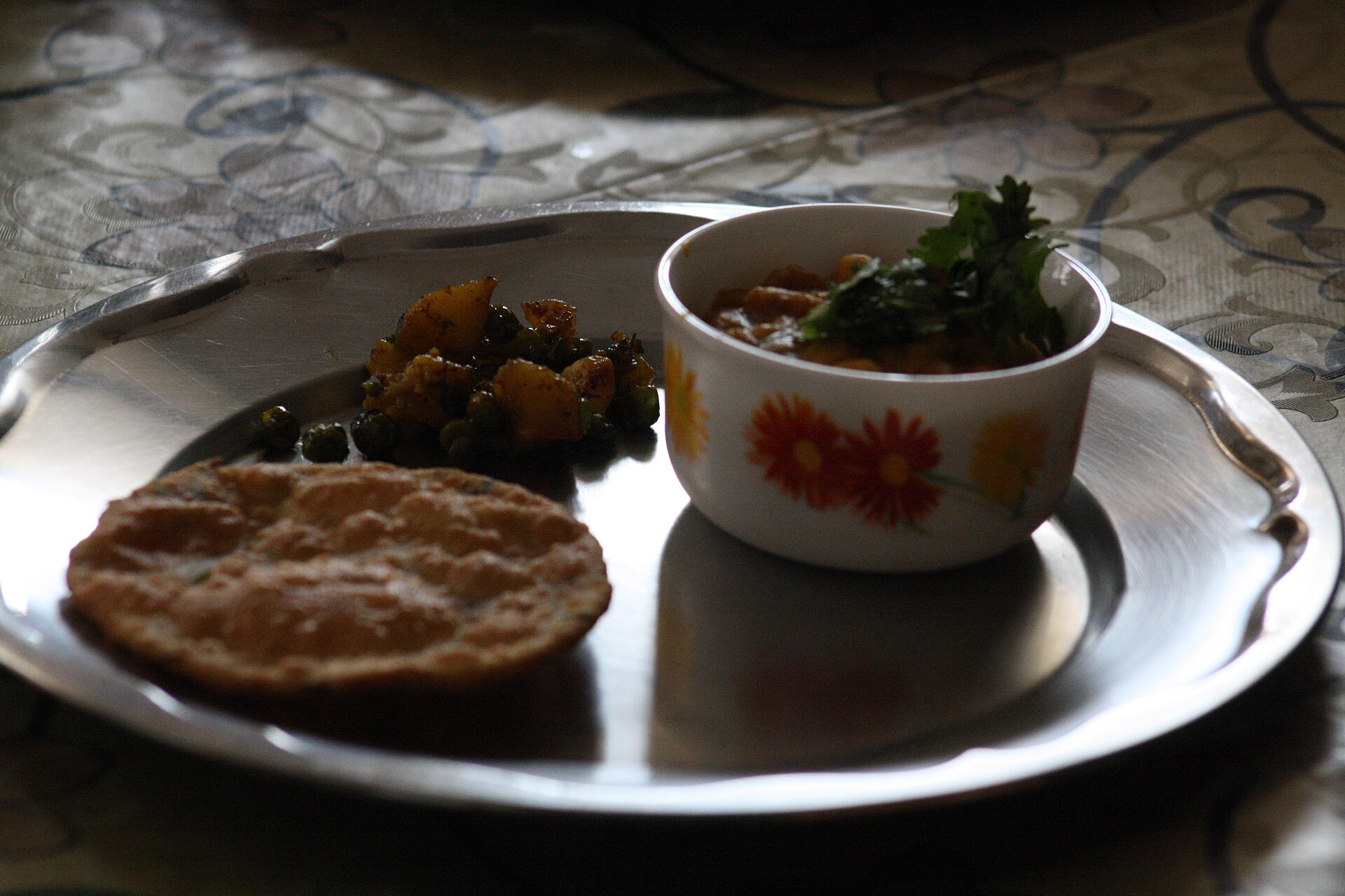 Kachori with potato sabzi on a steel plate, the Banarasi breakfast Ram Bhandar serves