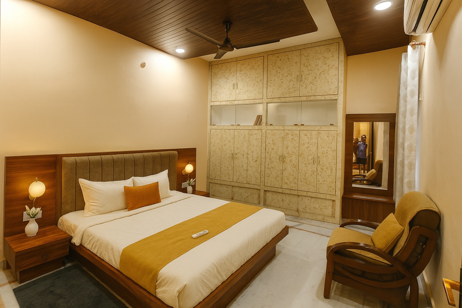 Pratham, Varanasi: bed with a padded headboard facing a full wall of fitted wardrobes, dressing mirror and a pair of wooden armchairs by the window